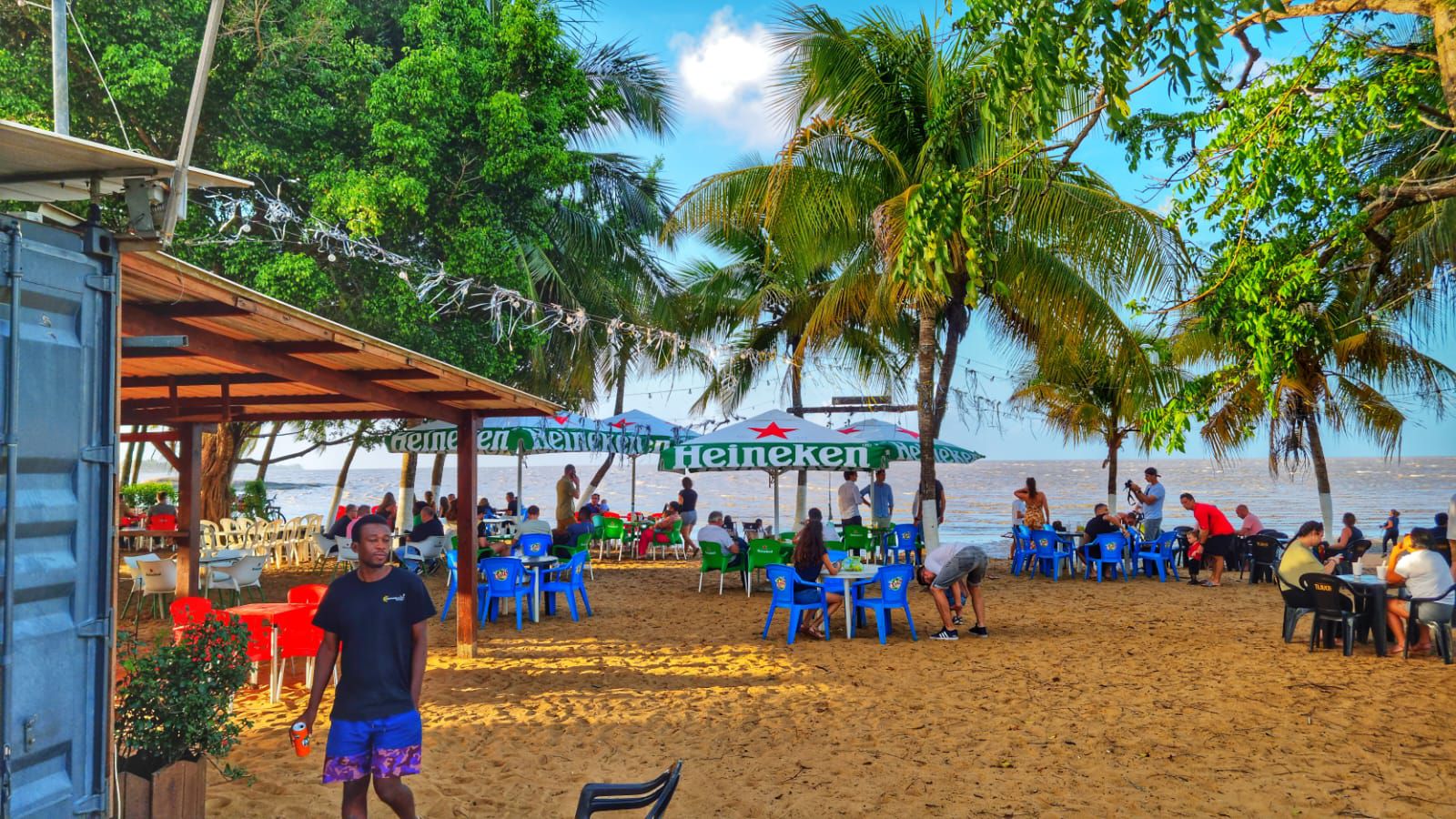 Terrasse du Copacabana en journée avec tables et parasols sur le sable