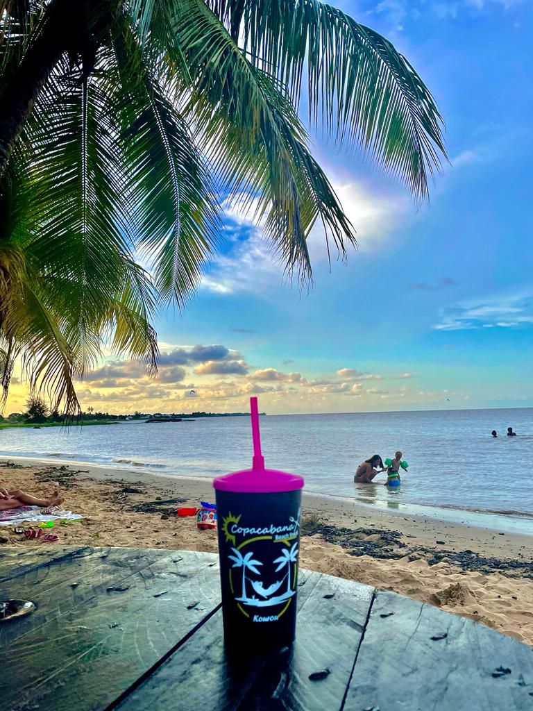 Verre Copacabana posé sur une table face à la plage de Kourou